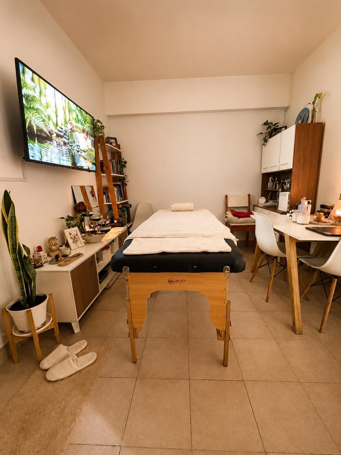 El espacio de Casa Mizu: la camilla en el centro, plantas, libros y luz cálida.